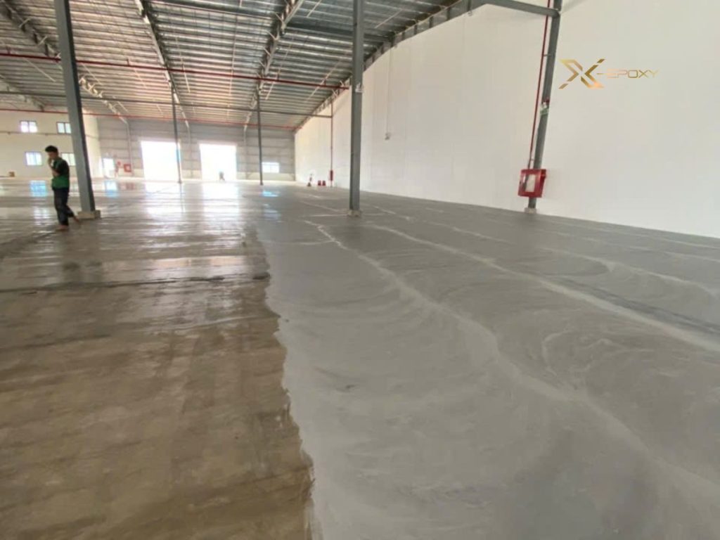 Bột đá CaCO3: Giải pháp xử lý nền xốp 3.500m² tại KCN Dầu Giây 7 Thợ kỹ thuật X-Epoxy gạt thủ công lớp bả hỗn hợp sơn và bột đá CaCO3 trên mặt sàn