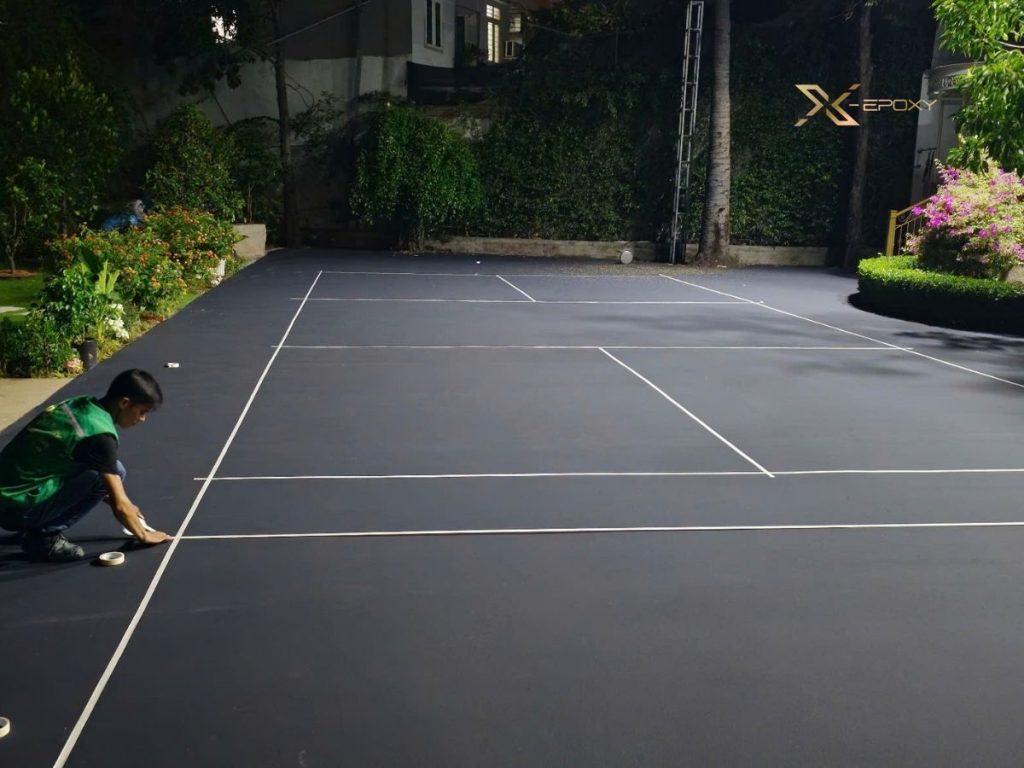 Cải tạo sân bê tông thành cụm sân thể thao đa năng tại Quận 7 10 Dán băng keo định vị và thi công line sân giúp phân chia rõ các khu vực vận động trên mặt sân.